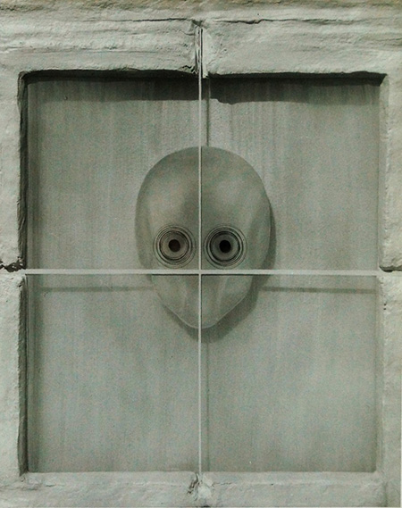 Cabeza mirando tras el cristal de una ventana